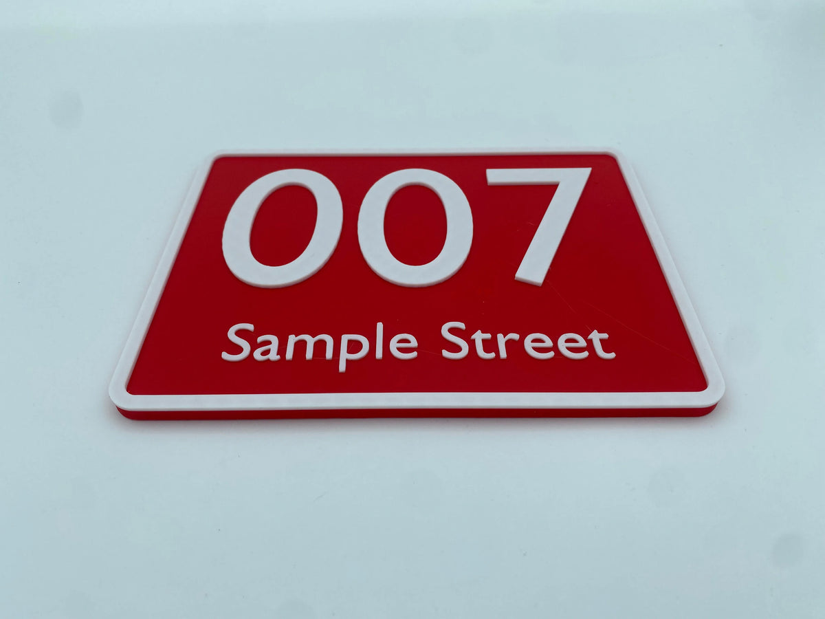 Red house number sign with white text, side angle