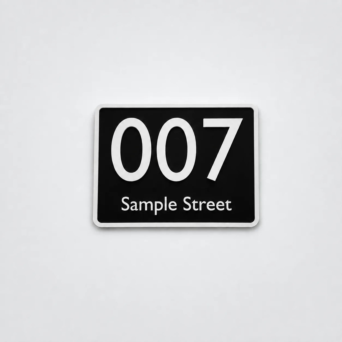 Black 3D-printed house number sign with white text