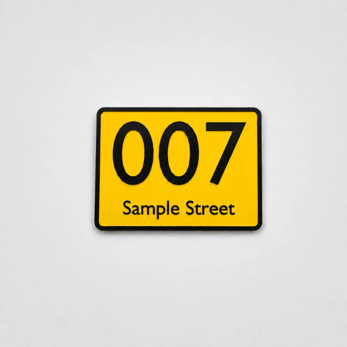 Yellow 3D-printed house number sign with black text