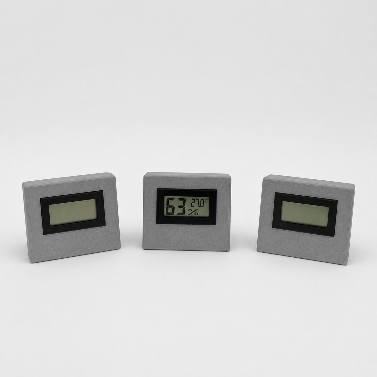 Grey temperature and humidity sensor shown from three front angles